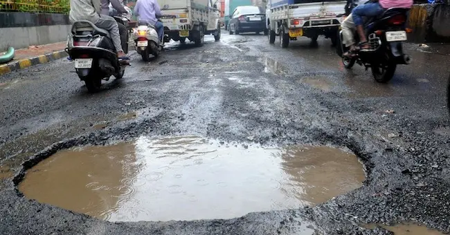  Protesters Garland Potholes -  గుంతల  రోడ్లపై  జనం ఆగ్రహం..గుంతలకు దండలు వేసి నిరసన