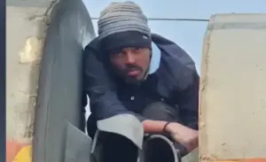 రైలు బోగీల మధ్య కూర్చొని యువకుడు ప్రమాదకర ప్రయాణం